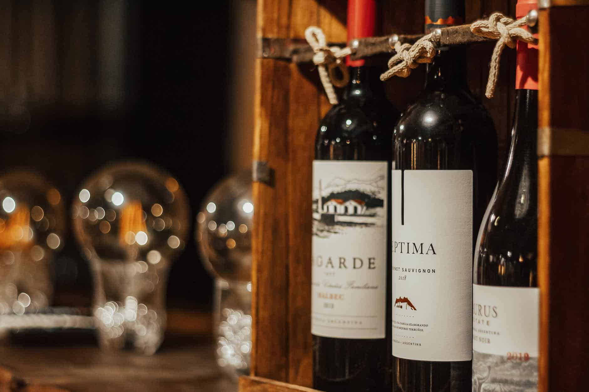 bottles of wine in wooden box arranged on table