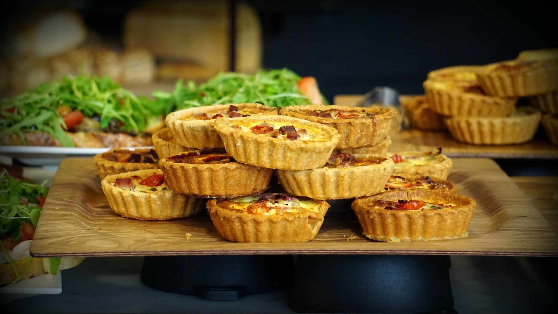 mini quiches op een houten borrelplank